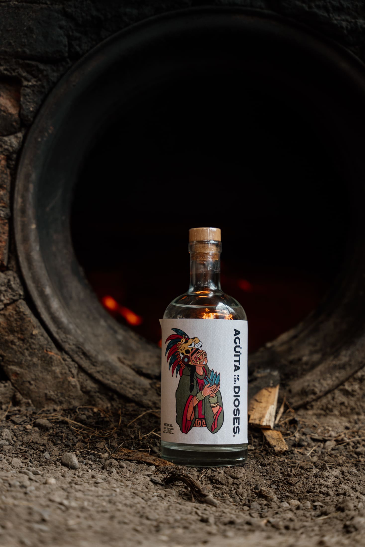 Bottle of mezcal lit by the oven's fire